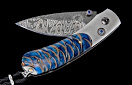 William Henry: Forst Glen knife
Knife Frame Type: titanium
Blade Type: damascus
Scale/Inlay: blue spruce pinecone
Gemstones/Embellishments: sapphire