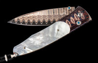 William Henry The Gentac ‘Belize’ features a frame of heat-blued 'Wave Mokume', inlaid with Mother of Pearl, 'Copper Wave' damascus blade. The one-hand button lock and the thumb stud are set with Kashmir blue topaz.