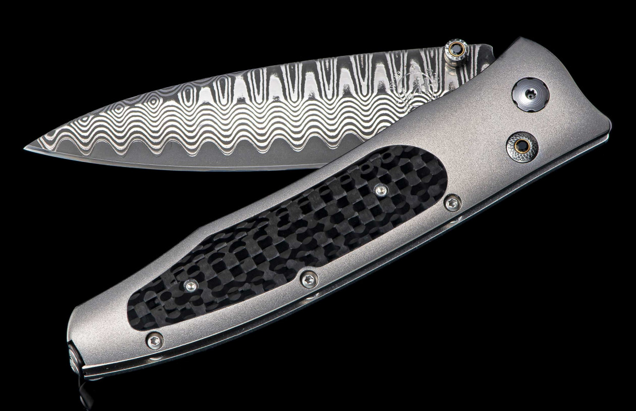 William Henry Knife Frame Type: Hi-Tech Titanium
Blade Type: 'Wave' Damascus With An Extra Strong Core Of Zdp-189
Scale/Inlay: Carbon Fiber
Gemstones/Embellishments:  Spinel Gem Stones